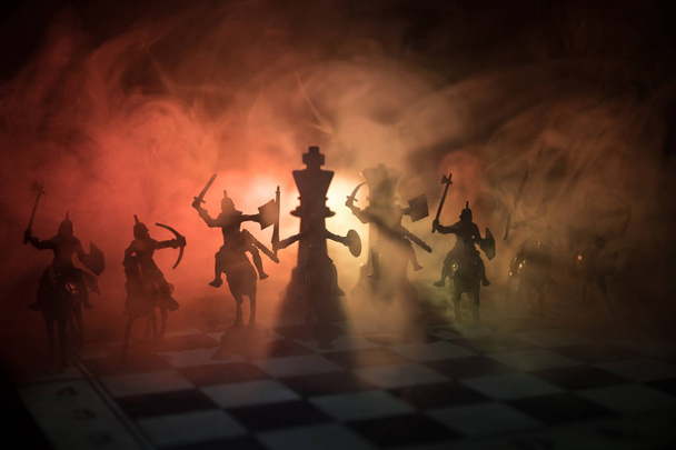 Μεσαιωνική μάχη σκηνή με ιππικό και πεζικό στη σκακιέρα. Έννοια επιτραπέζιο παιχνίδι σκάκι επιχειρηματικές ιδέες και ανταγωνισμού και ιδέες στρατηγική σκάκι φιγούρες σε σκούρο φόντο. Επιλεκτική εστίαση - Φωτογραφία, εικόνα