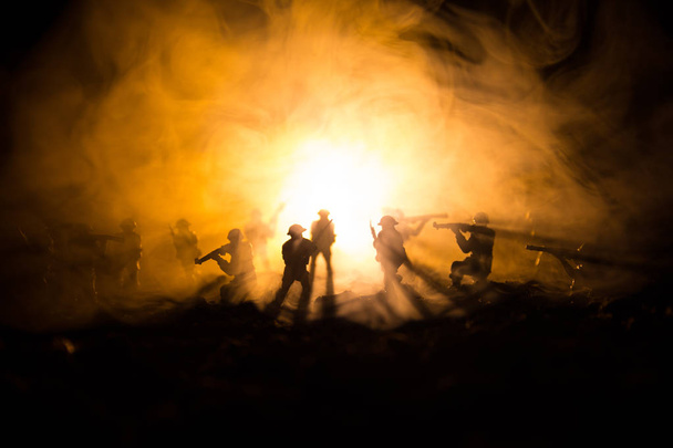 Concepto de guerra. Siluetas militares peleando escena en el fondo del cielo niebla de guerra, Soldados de la Guerra Mundial Siluetas debajo del horizonte nublado Por la noche. Escena de ataque. Vehículos blindados. Batalla de tanques
. - Foto, Imagen