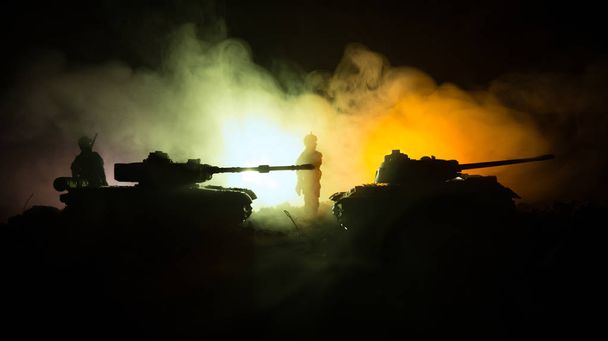 戦争の概念。戦争の霧空のシーンをかけて戦う軍のシルエットの背景、夜曇りスカイライン以下世界大戦兵士のシルエット。攻撃シーン。装甲車両。タンクは戦う. - 写真・画像