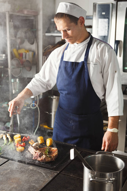 Шеф-кухар готує соковитий яловичий стейк на кухні ресторану
 - Фото, зображення