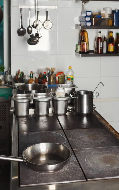 Modern restaurant kitchen interior with frying pans - Foto, afbeelding