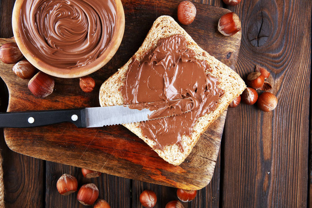 Homemade hazelnut spread with toast and in wooden bowl for break - Photo, Image