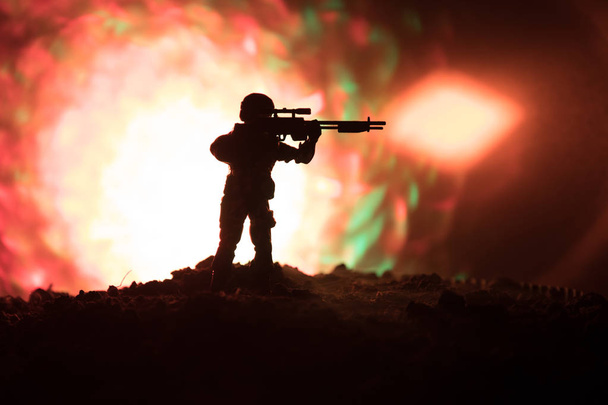 Армейский снайпер с крупнокалиберной снайперской винтовкой ищет убийцу врага. Силуэт на фоне неба. Национальная безопасность обеспечена, военнослужащие на страже
 - Фото, изображение