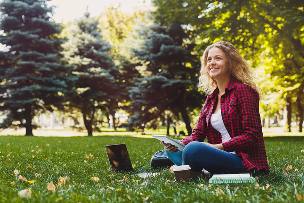 junge lässige Frau mit Laptop und Notizbuch im Freien - Foto, Bild