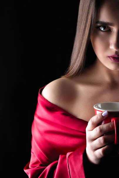 beautiful lady with super makeup in dark holding cup and drink - Fotoğraf, Görsel