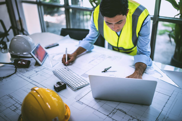 Architect working on blueprint.engineer inspective in workplace - architectural project, blueprints,ruler,calculator,laptop and divider compass. Construction concept. Engineering tools, working concept. - Photo, Image