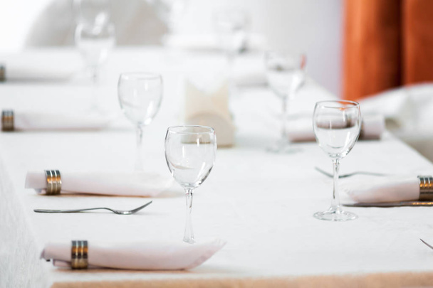Banquet decorated table, with cutlery. Wedding decor in the banquet hall.Serving of a festive table, plate, napkin, knife, fork. Table setting decoration. Romantic Dinner or other events. - 写真・画像
