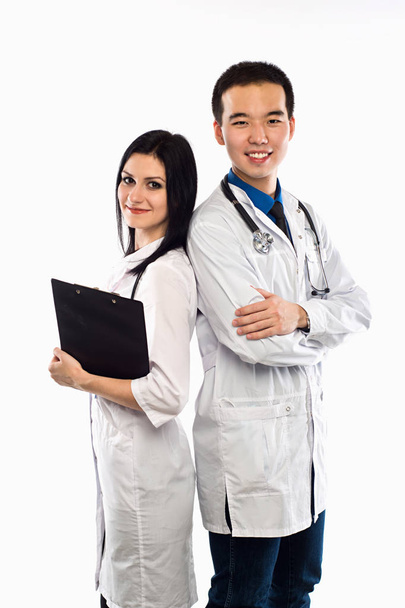 Счастливая команда из двух врачей, стоящих спиной к спине с руками.
 - Фото, изображение