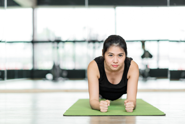 Krásná asijská žena dělá prkno cvičení na fitness mat v tělocvičně. fitness a zdravého životního stylu koncepce. - Fotografie, Obrázek