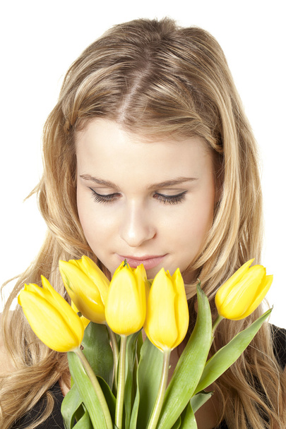 close up of a young woman with yellow tulips - 写真・画像