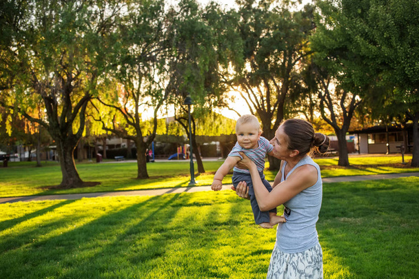 A mother with baby son in park - Фото, изображение