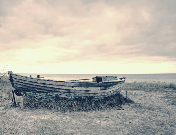 Bateau de pêche en bois naufragé. Bateau abandonné brisé dans le sable de la baie de la mer
. - Photo, image