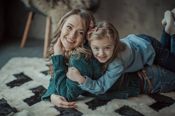 Smiling mother with her daughter in the room on the carpet - Foto, immagini