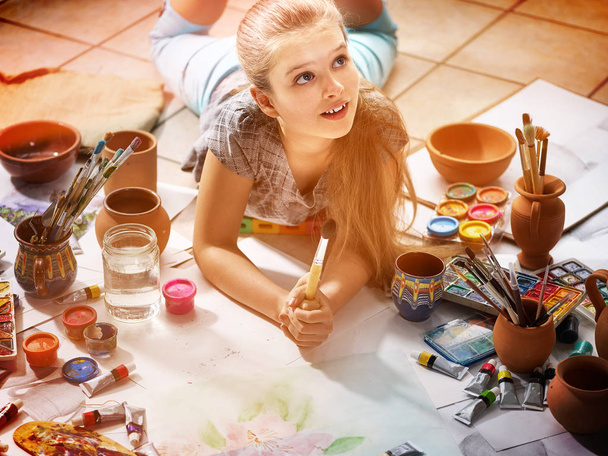 Authentic artist children girl paints on floor. Top view. - Photo, Image