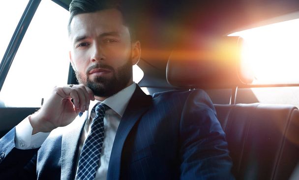 Successful businessman sitting in the back seat of a car - 写真・画像