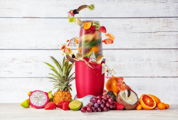 Smoothie maker mixer with pieces of fruit ingredients - Foto, Bild