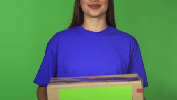Holding carboard gülümseyen bir teslimat kadının kırpılmış atış ile boşaltmak kutu - Video, Çekim