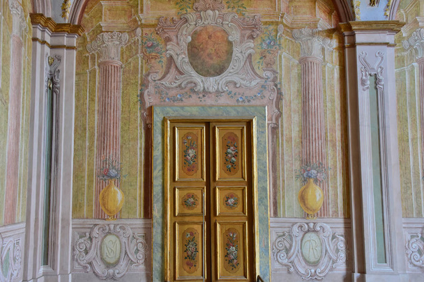 Италия, 13 октября 2017 года. Certosa of San Martino, год 1325, монументальный религиозный комплекс. Стена с фресками и декорированная дверь внутренней комнаты
. - Фото, изображение