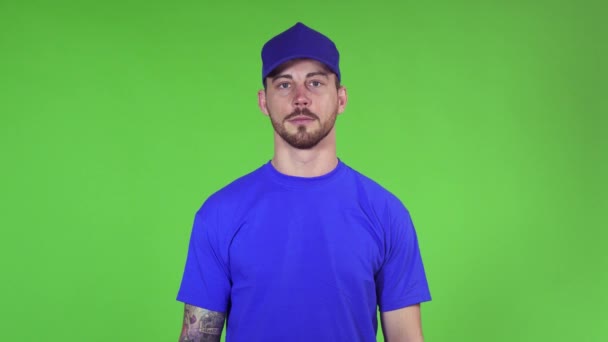 Zeker jonge mannelijke levering dienst werknemer poseren met zijn armen gevouwen - Video