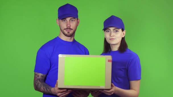Twee gelukkige professionele bezorgers stak pakket box naar de camera - Video