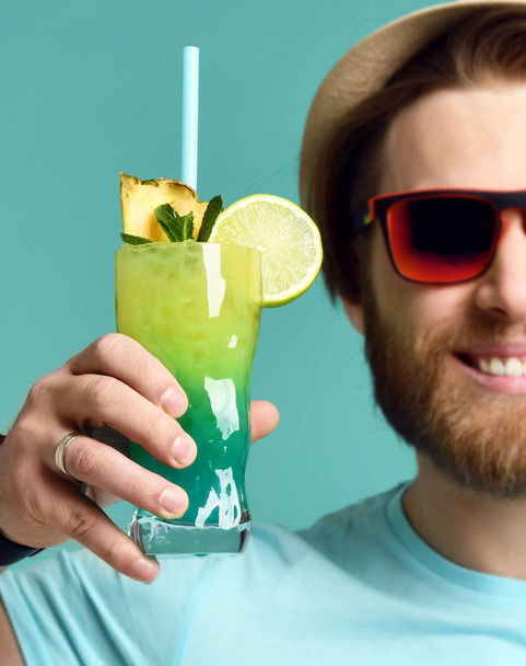 Young man in hat and red sunglasses hold margarita cocktail drink juice happy cheers - 写真・画像
