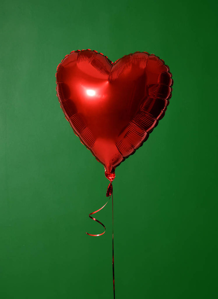 Single big  red heart balloon object for birthday party on green - Zdjęcie, obraz