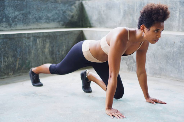 Mélanésienne fille athlète insulaire pacifique avec afro effectuer des routines d'exercice étirement
 - Photo, image