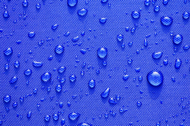 Bliska wzór krople wody na tle niebieski wodoodporne tkaniny.  - Zdjęcie, obraz