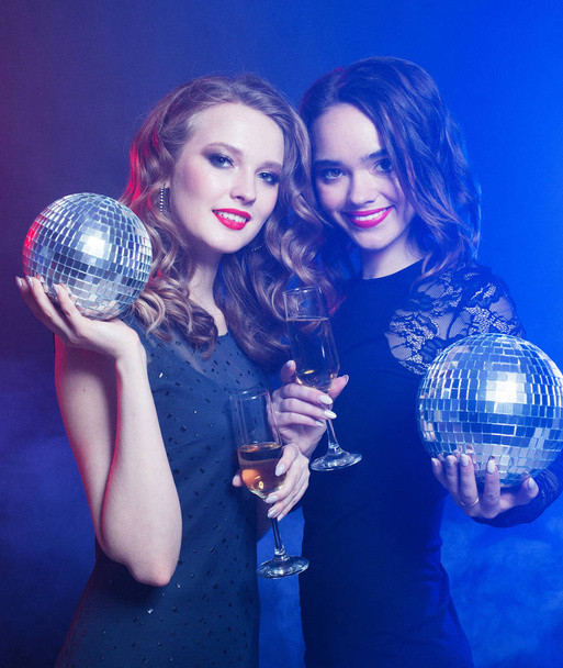 lifestyle and people concept: two beautiful   women with wine glasses and disco ball, party time - Zdjęcie, obraz