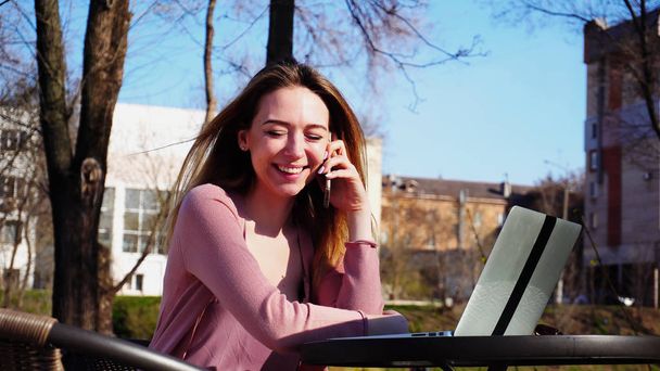 Молодая женщина разговаривает на смартфоне и просматривает ноутбук на фресах
 - Фото, изображение