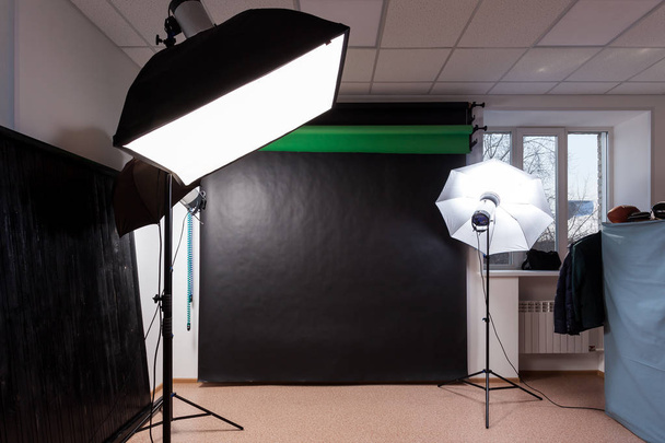 Photostudio com equipamento de estúdio: preto, verde, fundo branco para fotografia, flashes de estúdio, defletores, Octoboxes
 - Foto, Imagem
