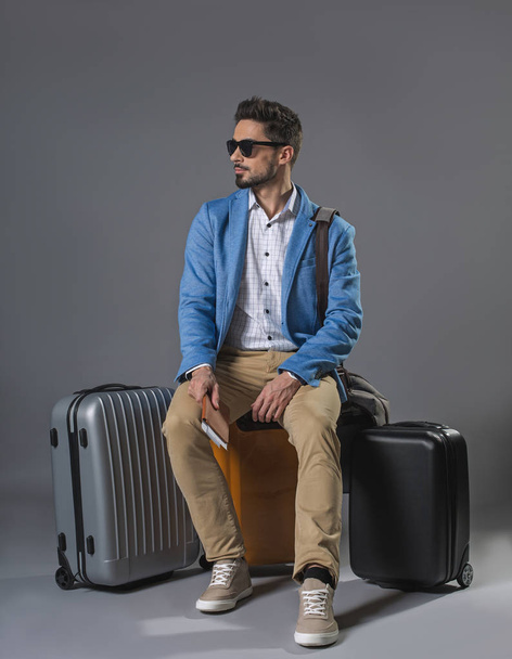 Waiting man sitting on suitcase - Фото, зображення