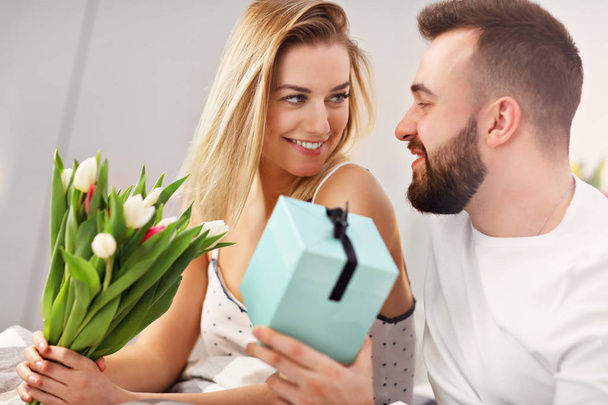 Adult attractive couple in bed with present - Photo, Image