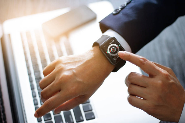 Руки бізнесмена торкаються розумного годинника. Використання додатка фондового ринку та графіку на сучасному віртуальному екрані для бізнесу. Технологія та концепція фінансових інвестицій
 - Фото, зображення