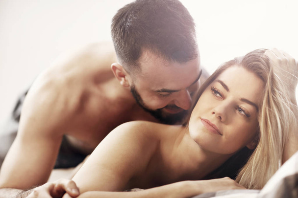 Sexy jonge geliefden wordt intieme in bed - Foto, afbeelding