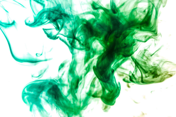 Thick colorful smoke of green on a white isolated background. Background from the smoke of vape - Photo, Image