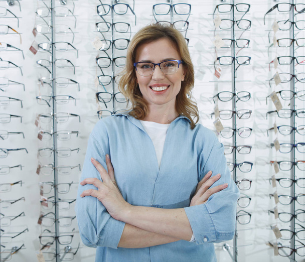 Cheerful woman locating in optical store - Photo, image