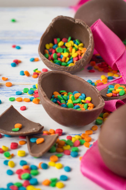 Великодні Шоколадні яйця, Рожева стрічка та різнокольорові солодощі на в  - Фото, зображення