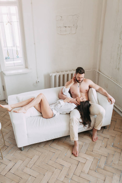Young happy couple at home, cuddling, and kissing are. Beautiful Sunny morning with your loved ones in pajamas mad and laugh. - Fotografie, Obrázek