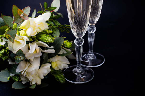 Dois copos de champanhe e buquê de flores brancas
 - Foto, Imagem