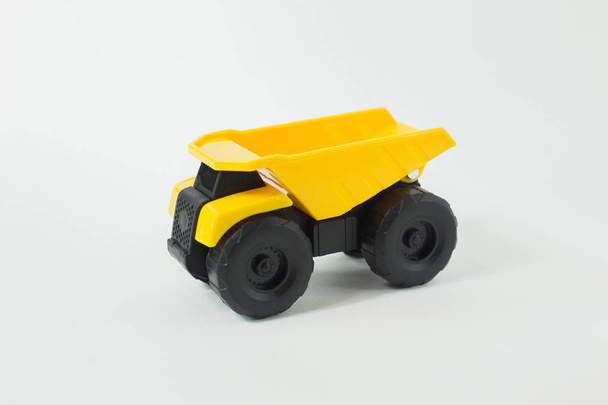  Κίτρινο ανατρεπόμενο φορτηγό παιχνίδι που απομονώνονται σε λευκό φόντο. - Φωτογραφία, εικόνα