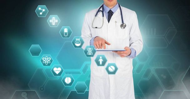 Digital composite of Male doctor holding tablet with medical interface hexagon icons - Photo, image
