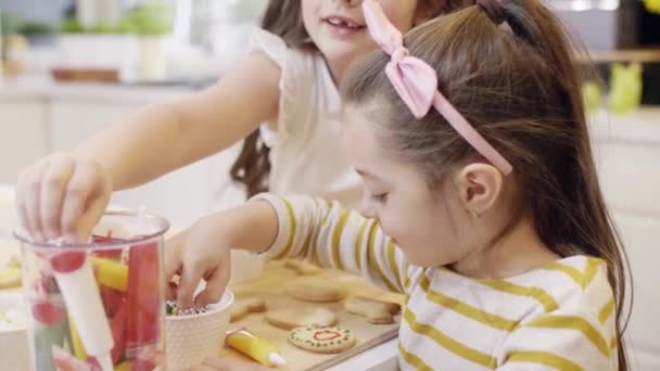 Dzieci, dekorowanie ciasteczek w kuchni  - Materiał filmowy, wideo