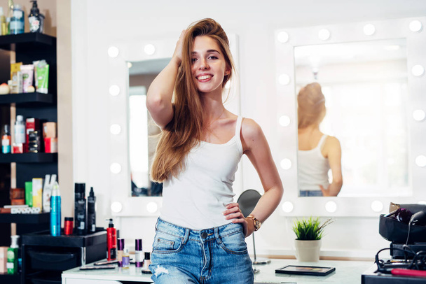 Portrait of cheerful hair stylist wearing casual clothes standing in hairdressing salon - Photo, Image