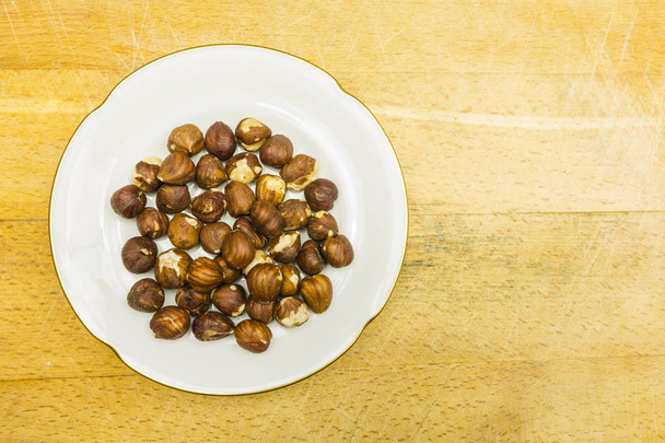 Plate with hazelnuts. View from above. - Photo, Image