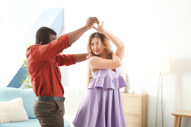 Cute interracial couple dancing at home - Valokuva, kuva