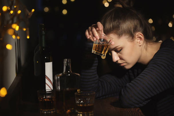 Young woman with glass of drink in bar. Alcoholism problem - Foto, Bild