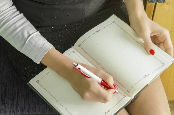 Business woman hand is writing on notepad with pen - Foto, Imagem