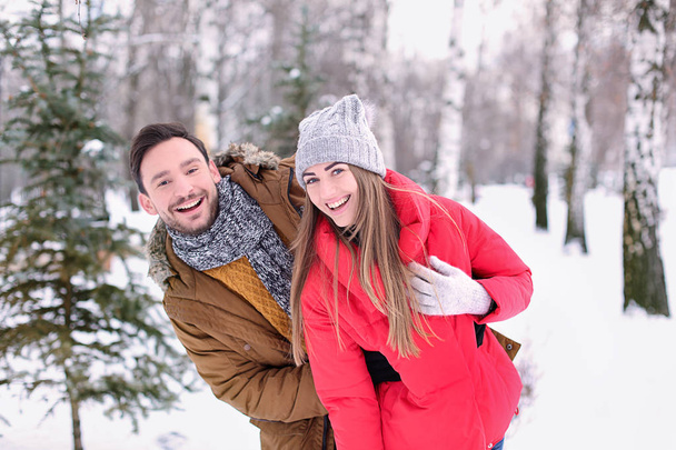 junges Paar im verschneiten Park im Winterurlaub - Foto, Bild