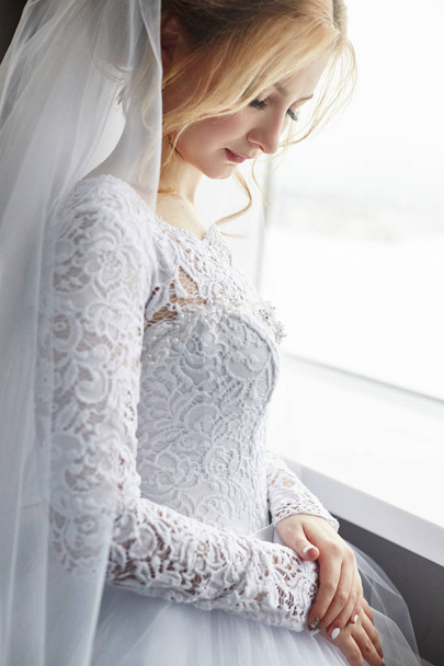 Blonde bride in a white wedding dress and a long veil is waiting - Фото, изображение